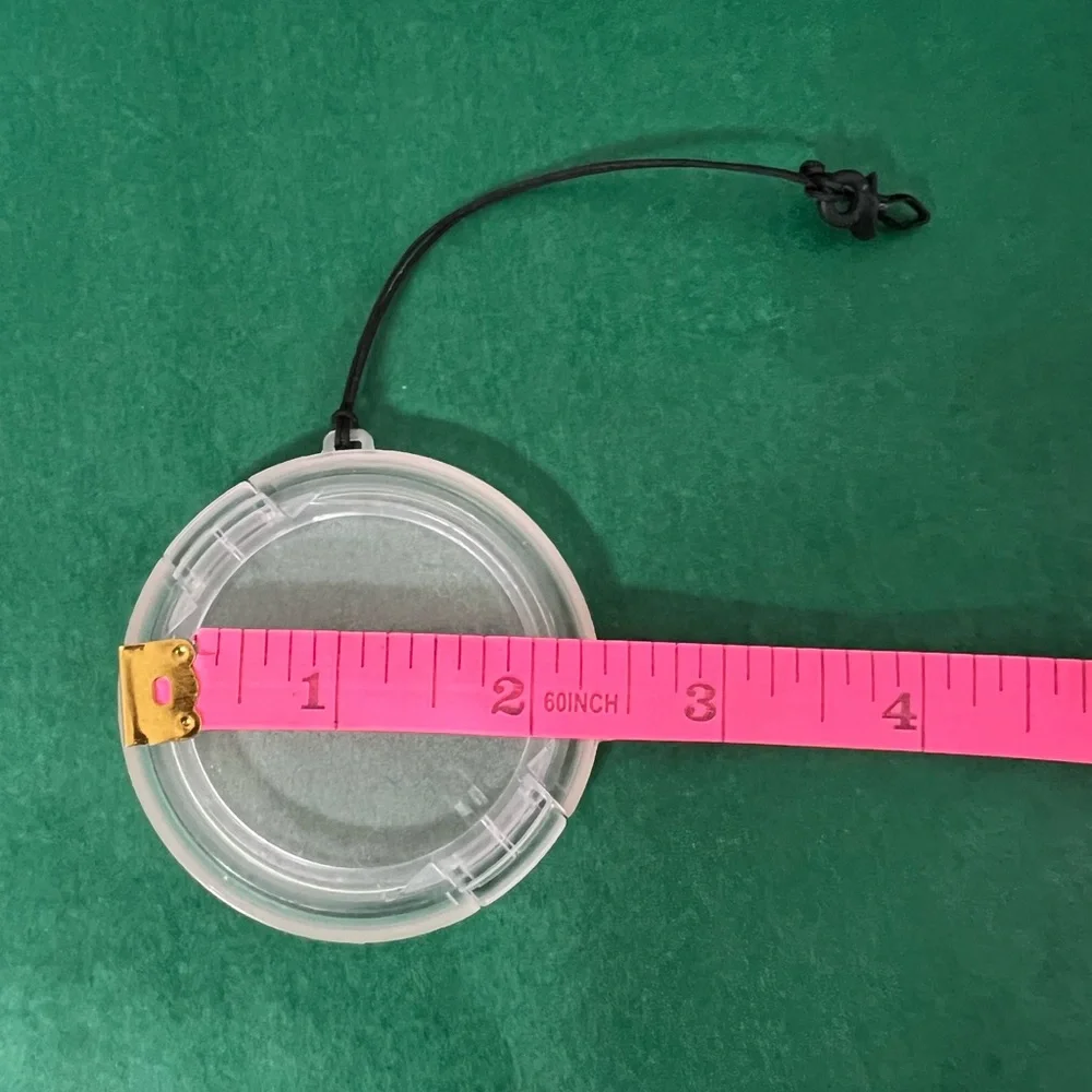 Plastic camera lens cover with string attachment